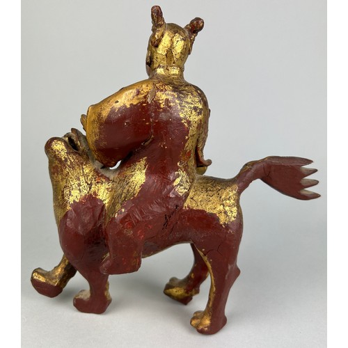 118 - A CHINESE RED LACQUERED AND GILT WOOD FIGURE RIDING A LION, 

21cm x 19cm