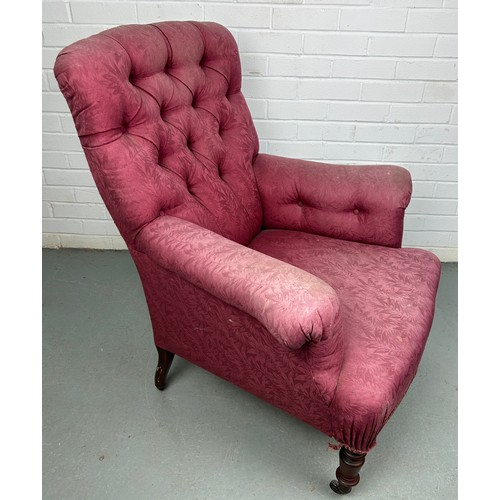 279 - A VICTORIAN BUTTON BACK ARMCHAIR IN THE MANNER OF HOWARD AND SONS, 

Upholstered in raspberry colour... 