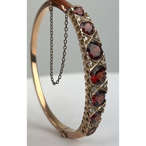 92 - A VICTORIAN 9CT GOLD BANGLE SET WITH SEVEN RED GARNETS OF GRADUATING SIZE, 

6.5cm in diameter x 6cm... 