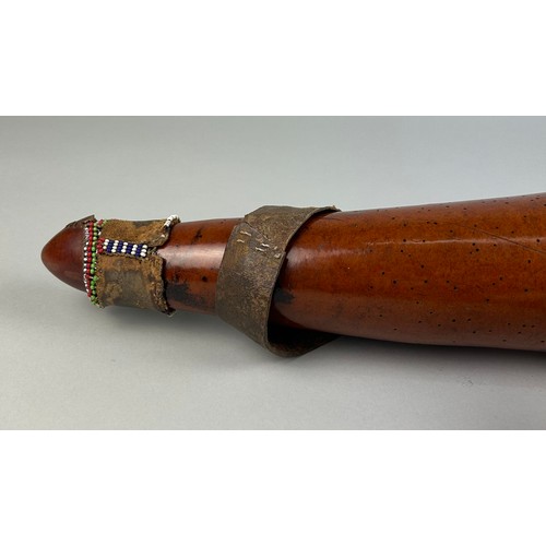 123A - A TRIBAL WATER FLASK WITH APPLIED BEADS

53cm in length.