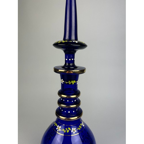 324 - A LARGE BLUE BOHEMIAN GLASS DECANTER GILT DECORATED WITH FLOWERS,

53cm x 14cm