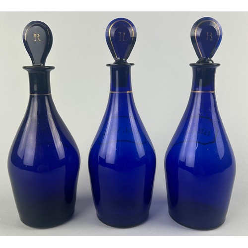 332 - A SET OF THREE BRISTOL BLUE GLASS DECANTERS AND STOPPERS WITH GILT LABELS (3) 

Labelled for Rum, Br... 