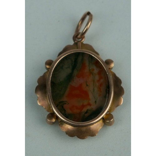 195 - A DENDRITIC AGATE SET IN A FLORAL GOLD PENDANT,

Weight: 4.3gms 
Stone: 20mm x 16mm