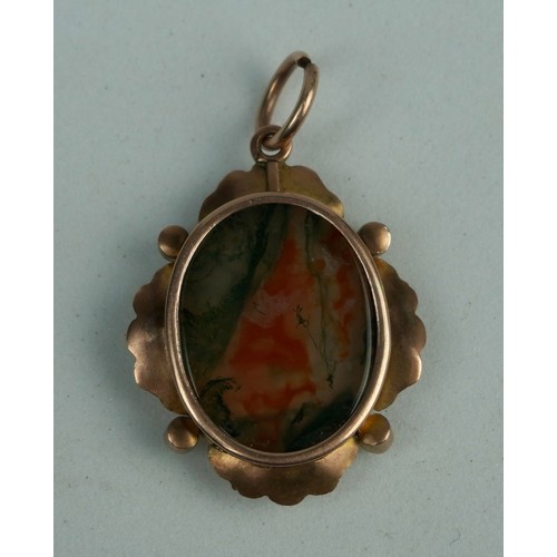 195 - A DENDRITIC AGATE SET IN A FLORAL GOLD PENDANT,

Weight: 4.3gms 
Stone: 20mm x 16mm