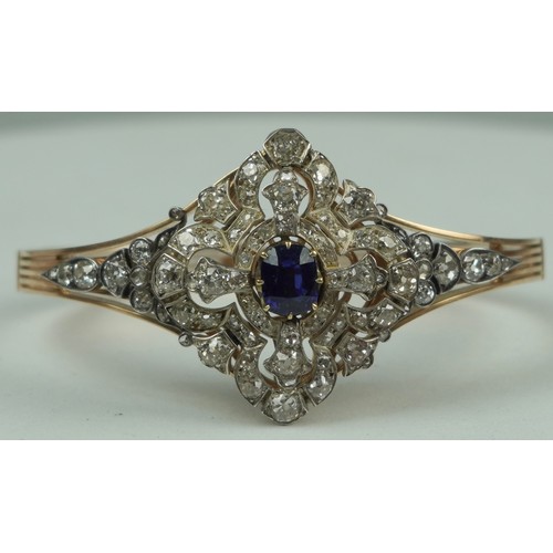 160 - A FINE 14CT GOLD BANGLE WITH CENTRAL CLAW SET SAPPHIRE SURROUNDED BY DIAMOND CLUSTERS,

Multi functi... 