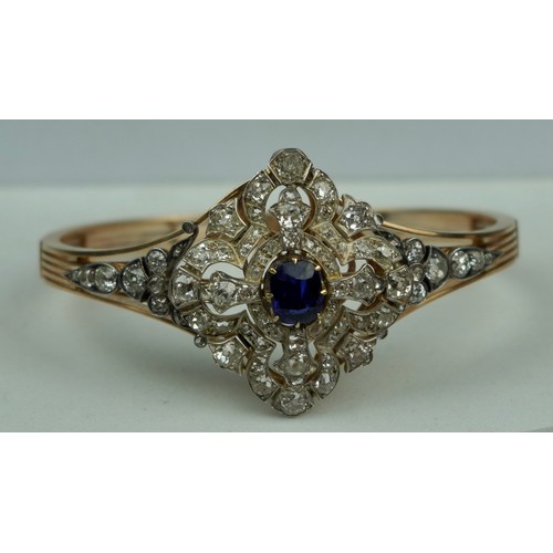 160 - A FINE 14CT GOLD BANGLE WITH CENTRAL CLAW SET SAPPHIRE SURROUNDED BY DIAMOND CLUSTERS,

Multi functi... 