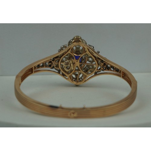 160 - A FINE 14CT GOLD BANGLE WITH CENTRAL CLAW SET SAPPHIRE SURROUNDED BY DIAMOND CLUSTERS,

Multi functi... 