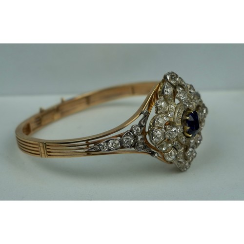 160 - A FINE 14CT GOLD BANGLE WITH CENTRAL CLAW SET SAPPHIRE SURROUNDED BY DIAMOND CLUSTERS,

Multi functi... 