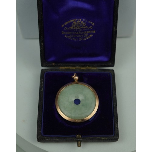 159 - A CHINESE JADE BI SET IN 9CT GOLD, 

In Goldsmiths and Silversmiths Company case. 

Weight: 8.55gms ... 