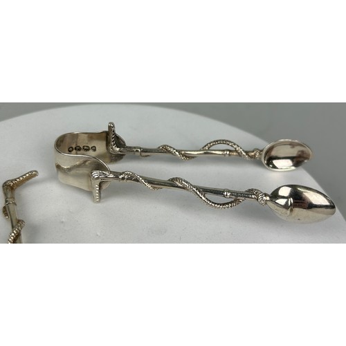 131A - A SET OF LATE 19TH SILVER CENTURY TEASPOONS IN THE FORM OF RIDING CROPS ALONG WITH A PAIR OF TONGS B... 