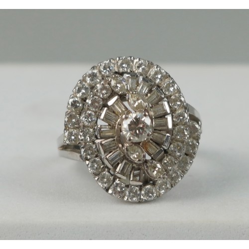 176 - AN 18CT WHITE GOLD RING OF 'WHIRL' DESIGN SET WITH DIAMONDS, 

Weight: 6.9gms 

One baguette cut dia... 