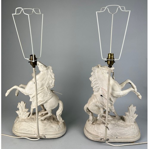 478 - EQUESTRIAN INTEREST: A PAIR OF WHITE PAINTED METAL LAMPS IN THE FORM OF A REARING HORSE AND TRAINER ... 