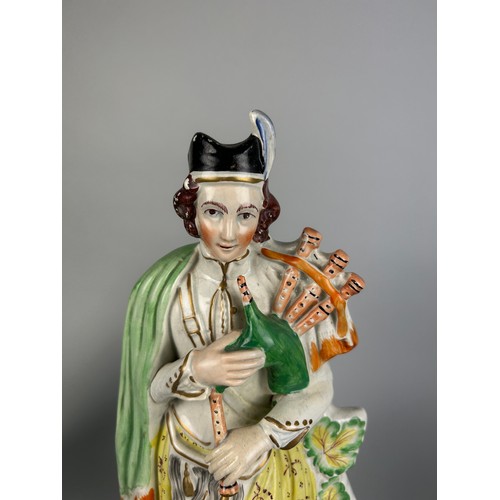 412 - A STAFFORDSHIRE FIGURE OF A HIGHLANDER WITH BAGPIPES,

40cm H