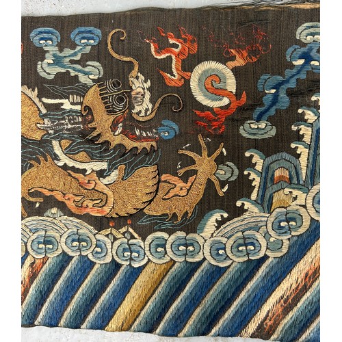 93 - A LARGE CHINESE SILK BANNER DECORATED WITH A FIVE CLAW DRAGON CHASING THE FLAMING PEARL, 

215cm x 2... 