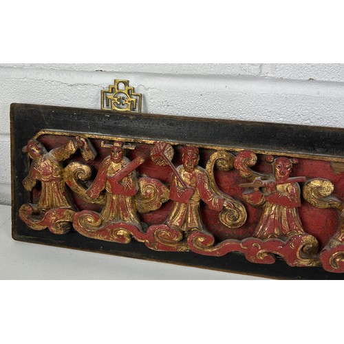 99A - A CHINESE RED LACQUER AND GILT CARVED WOOD PANEL DEPICTING FIGURES,

67cm x 14cm