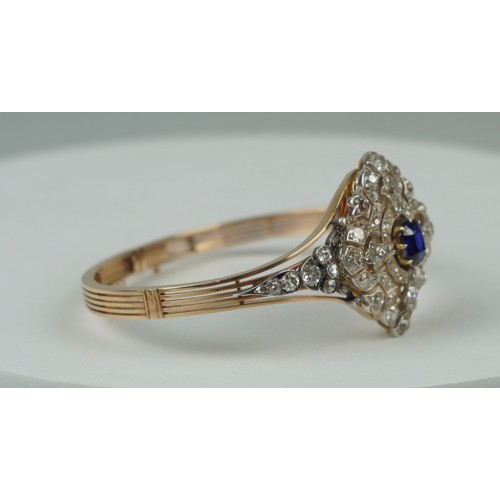 160 - A FINE 14CT GOLD BANGLE WITH CENTRAL CLAW SET SAPPHIRE SURROUNDED BY DIAMOND CLUSTERS,

Multi functi... 