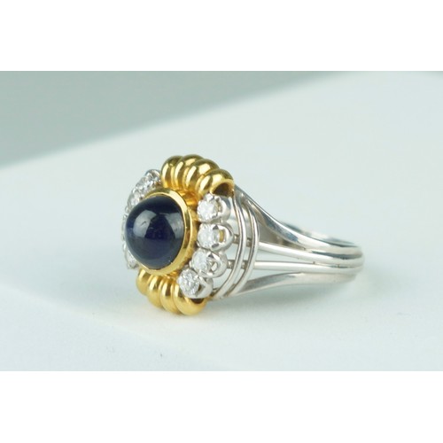 179 - AN 18CT GOLD RING SET WITH A SAPPHIRE AND EIGHT DIAMONDS  8.9gms