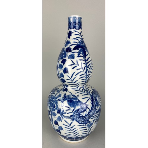 114C - A CHINESE BLUE AND WHITE DOUBLE GOURD VASE DECORATED WITH A DRAGON, 

36cm H