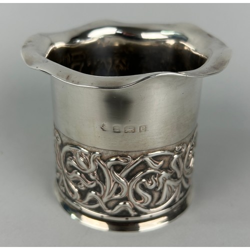 293 - AN ARTS AND CRAFTS SILVER CUP DECORATED WITH REPOUSSE FLOWERS.

Weight 107gms