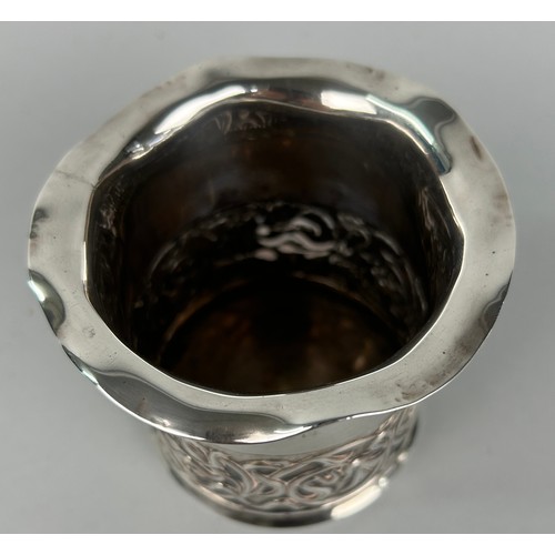 293 - AN ARTS AND CRAFTS SILVER CUP DECORATED WITH REPOUSSE FLOWERS.

Weight 107gms