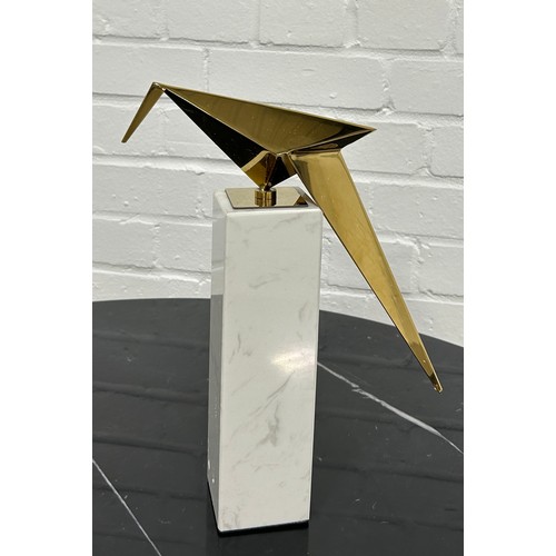 566 - EICHOLTZ: A MODERNIST TABLE SCULPTURE OF A GILT BRASS BIRD ON A MARBLE STAND.