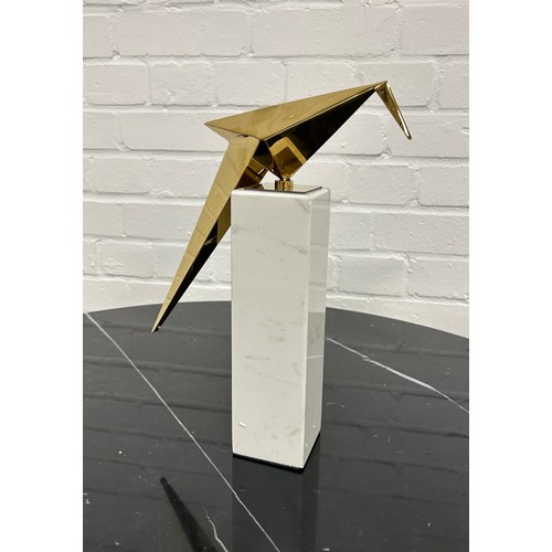 566 - EICHOLTZ: A MODERNIST TABLE SCULPTURE OF A GILT BRASS BIRD ON A MARBLE STAND.