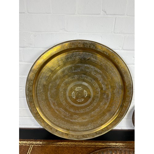 223 - A LARGE ISLAMIC BRASS DISH ALONG WITH A SMALLER EXAMPLE AND A COPPER DISH,

Largest 59cm D