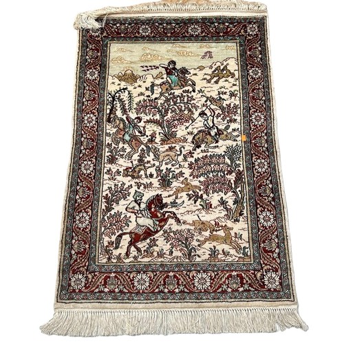 633 - A PERSIAN DESIGN SILK CARPET DEPICTING HUNTERS AND RIDERS, 

93cm x 62cm