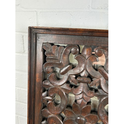 567 - A CARVED FLORAL SCROLL OAK PANEL WITH MIRRORED BACK, 

56cm x 35cm x 5cm