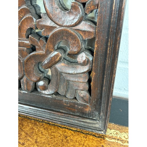 567 - A CARVED FLORAL SCROLL OAK PANEL WITH MIRRORED BACK, 

56cm x 35cm x 5cm