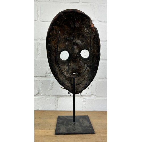 238 - AN AFRICAN TRIBAL MASK MOUNTED ON STAND,

24cm x 14cm 
On stand 32cm H