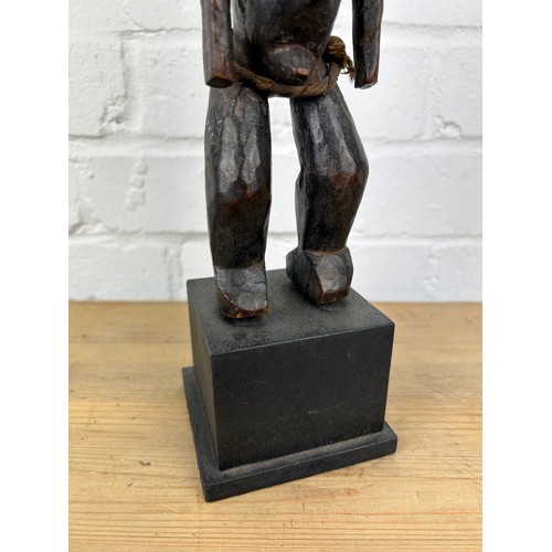 242 - AN AFRICAN TRIBAL WOODEN MALE FIGURE, 

Mounted on wooden stand. 

28cm H
On stand 36cm H