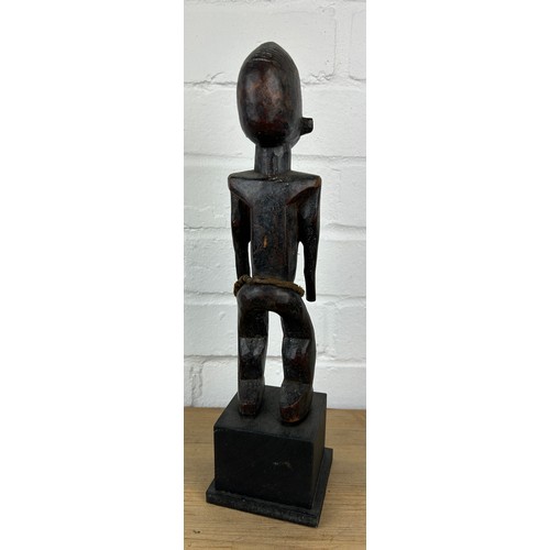 242 - AN AFRICAN TRIBAL WOODEN MALE FIGURE, 

Mounted on wooden stand. 

28cm H
On stand 36cm H