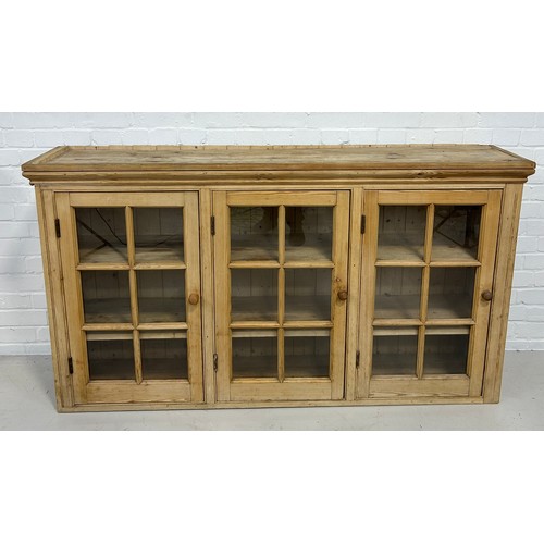 572 - A LARGE PINE BOOKCASE WITH THREE GLAZED DOORS REVEALING A SHELVED INTERIOR, 

162cm x 92cm x 35cm