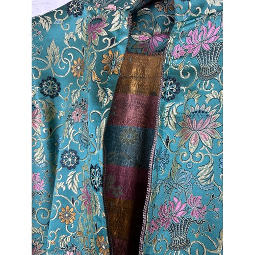 220 - A CHINESE GREEN SILK ROBE DECORATED WITH FLOWERS, 

Along with a black and gold thread dress.