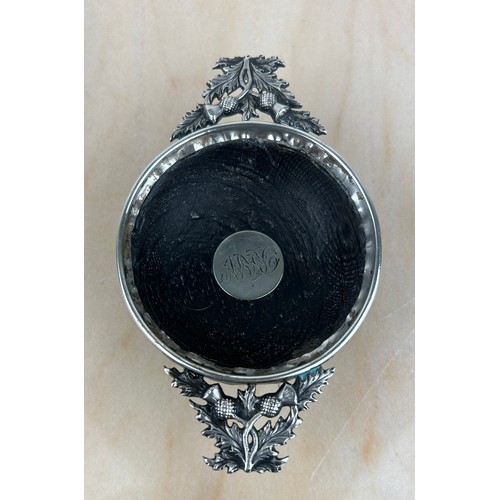 301 - A SCOTTISH QUAICH TOASTING BOWL WITH SILVER THISTLE HANDLES, 

Engraved initials to centre. 

12cm x... 