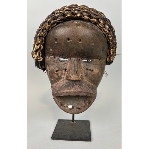 608 - AN AFRICAN TRIBAL MASK WITH SHELL DETAIL, 

26cm x 20cm 

Mounted on stand 32cm H