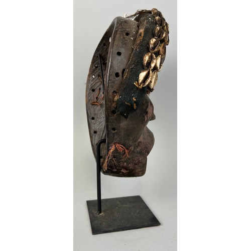 608 - AN AFRICAN TRIBAL MASK WITH SHELL DETAIL, 

26cm x 20cm 

Mounted on stand 32cm H