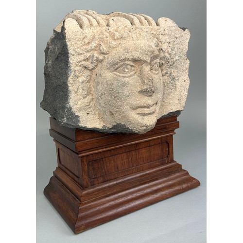 4 - AN EAST ROMAN 'HAURAN' BASALT RELIEF FRAGMENT IN THE FORM OF A HUMAN HEAD CIRCA 2ND CENTURY A.D. 

T... 