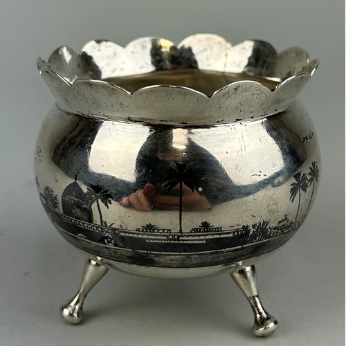 163 - AN ARABIC SILVER BOWL ON TRIPOD STAND, 

Nielo decorated with palm trees. 

Signed to the side. 

We... 