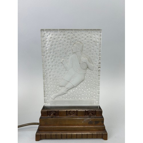 489 - AN ART DECO VERLYS PRESSED GLASS LIGHT ON STAND IN THE FORM OF A RUGBY PLAYER, 

30cm x 19cm