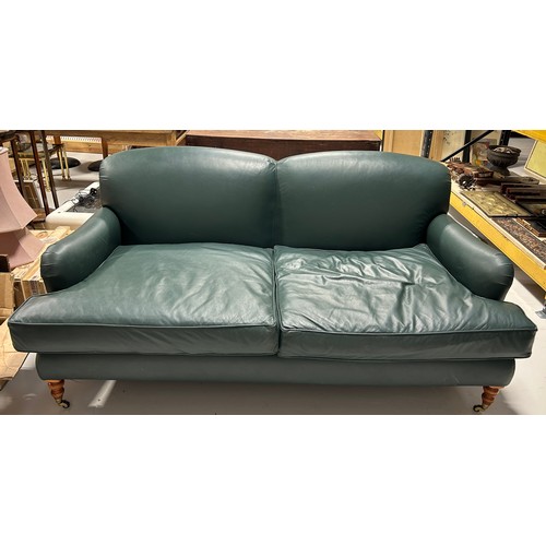 445 - A LARGE TWO SEATER HOWARD STYLE SOFA UPHOLSTERED IN GREEN LEATHER FABRIC, 

Raised on four legs, the... 