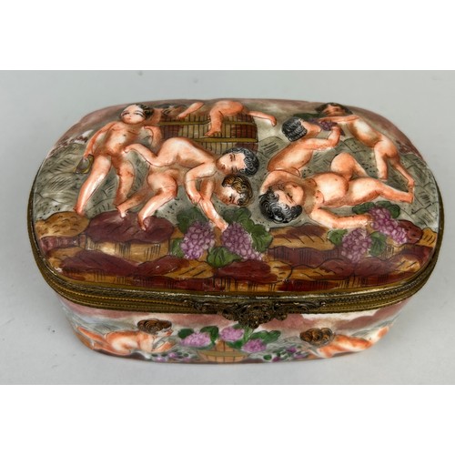 560 - A CAPODIMONTE BOX DECORATED WITH PUTTI, 

Marked to verso. 15cm x 10cm x 8cm