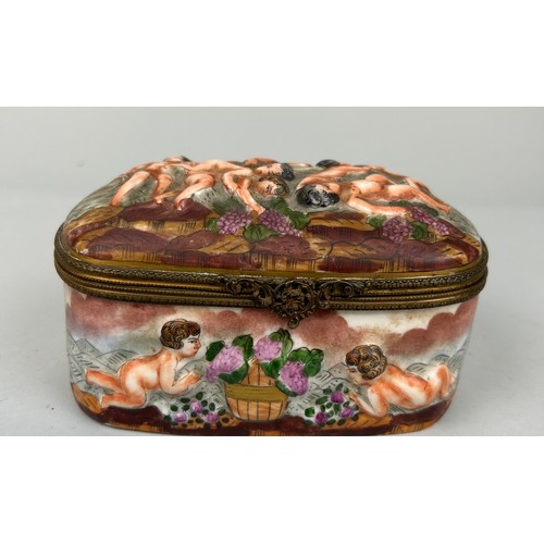 560 - A CAPODIMONTE BOX DECORATED WITH PUTTI, 

Marked to verso. 15cm x 10cm x 8cm