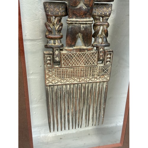 522 - AN ANTIQUE AFRICAN BRONZE COMB, 

30cm x 10cm 

Mounted in a glass display case and glazed.
56cm x 3... 