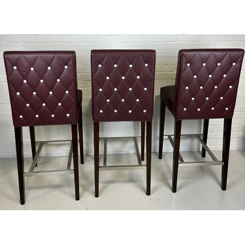 607C - A SET OF THREE BAR STOOLS BY BEN WHISTLER UPHOLSTERED IN BURGUNDY LEATHER WITH WHITE BUTTON BACK, 

... 