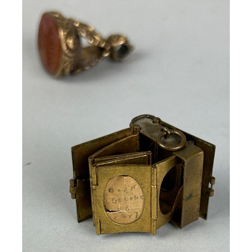 133 - A SILVER AND HORN HAIR PIN ALONG WITH A GILT METAL AND CAMEO INTAGLIO SEAL AND A SMALL BRASS BOOK (3... 