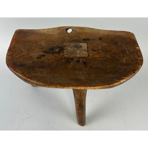 425 - A PRIMITIVE OAK MILKING STOOL ON THREE LEGS, 

34cm x 27cm