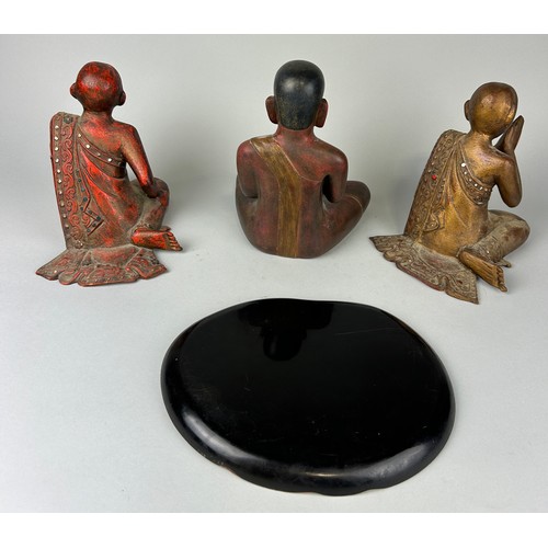 64 - A GROUP OF THREE CARVED WOODEN BUDDHA'S ALONG WITH A RED AND BLACK LACQUERED TRAY, 

Largest Buddha ... 