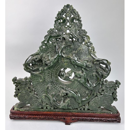 243 - A LARGE CHINESE GREEN STONE SCULPTURE,

40cm x 40cm 

Mounted on a wooden stand.